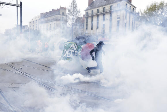 Des jeunes fuient les gaz lacrymogènes lors d’une manifestation jeudi 6 avril 2023 à Nantes.