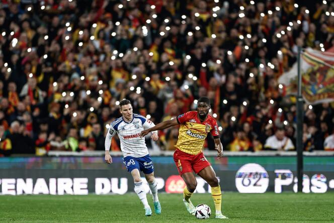 Lensois defender Kevin Danso (yellow jersey) in front of Strasbourg striker Kevin Gameiro, April 7, 2023 at the Bollaert-Delelis stadium in Lens.