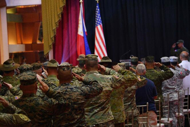 American and Filipino soldiers salute their two flags during the opening ceremony of Operation Policatan near Manila on April 11.