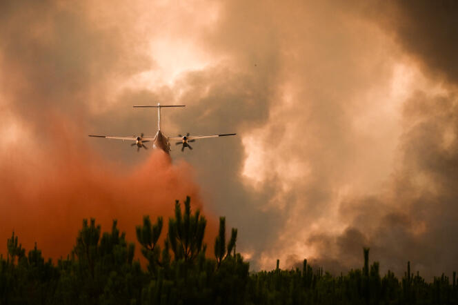 Un avión de bomberos Dash 8 rocía retardante de fuego en los árboles durante un incendio forestal cerca de Belin-Beliet (Gironda), el 10 de agosto de 2022. 