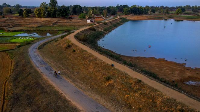 A villager sits on the shore of a lake in Haripur village in Ambikapur district, Chhattisgarh state, India, Monday, March 20, 2023.