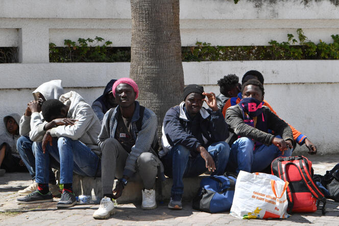 Migrantes esperan afuera de la sede de la OIM en Túnez el 11 de abril de 2023, luego de que las fuerzas de seguridad desmantelaron su campamento.