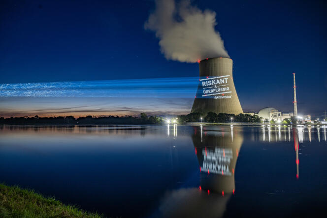 Activistas de Greenpeace proyectan 'Arriesgado e innecesario' en la torre de enfriamiento de la planta de energía nuclear Isar 2, en Essenbach, Baviera, el 12 de septiembre de 2022.