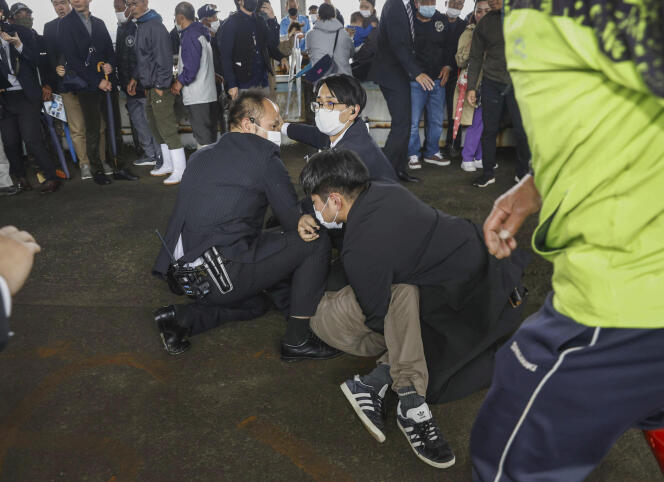Un hombre retenido en el suelo por la policía bajo sospecha de haber arrojado una bomba de humo al primer ministro japonés Fumio Kishida en el puerto pesquero de Wakayama, Japón, el 15 de abril de 2023.