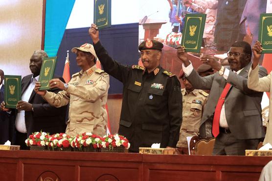 El jefe del ejército sudanés Abdel Fattah Al-Bourhane (centro derecha) y el comandante paramilitar Mohamed Hamdan Dagalo (centro izquierda), durante la firma de un acuerdo provisional para poner fin a la profunda crisis sufrida por el golpe militar de 2021, en Jartum (Sudán), el 1 de diciembre de 2020. 5, 2022.