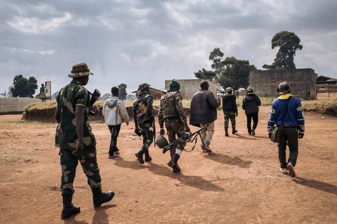 Commanders of the armed group URDPC/CODECO (Union des Révolutionnaires pour la Défense du Peuple Congolais/Coopérative pour le Développement du Congo) walk through the village of Linga on January 13, 2022, in Ituri province, northeastern Democratic Republic of Congo.