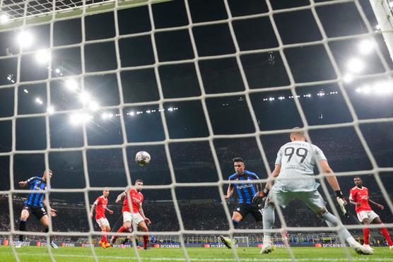 L'attaccante dell'Inter Argentina Lautaro Martinez (maglia a righe al centro) calcia il pallone in fondo alla rete contro il Benfica il 19 aprile 2023 a Milano.