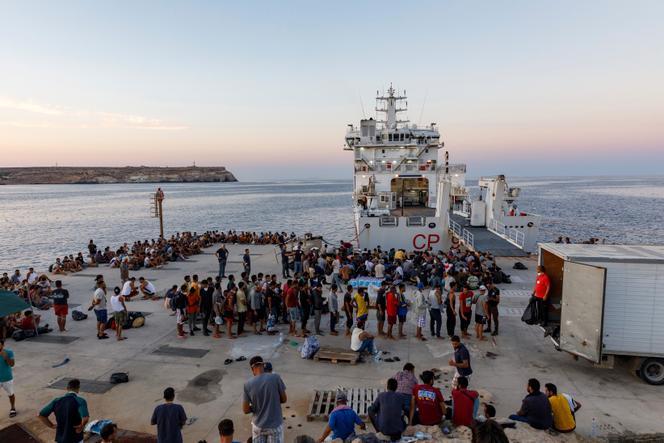 Migrantes esperan para abordar un barco de la guardia costera italiana en la isla siciliana de Lampedusa, Italia, el 3 de agosto de 2022.