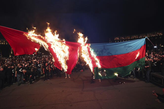 Protesters burn Turkish and Azerbaijani flags during the commemoration of the Armenian Genocide in Yerevan on April 23, 2023. 