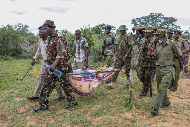 Security personnel carry a young person rescued from the forest in Shakahola, Kenya on April 23, 2023.