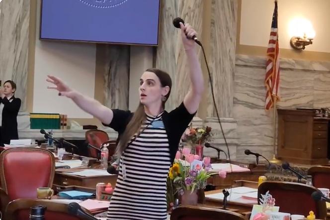 Montana Democratic Representative Zooey Zephyr hoists a microphone into the air on Monday, April 24, 2023, as her supporters interrupt proceedings in the state House by chanting