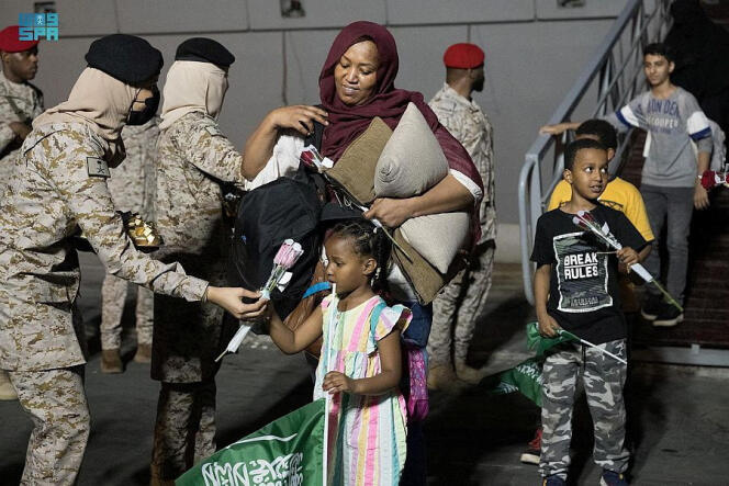 Saudi soldiers greet civilians arriving from Sudan in Jeddah on April 27, 2023.