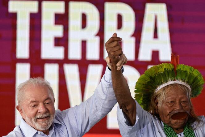 Brazil's President Luiz Inacio Lula da Silva waves with Brazil's indigenous chief Raoni Metuktire, during the closing of the Terra Livre (Free Land) camp, a protest camp to demand the demarcation of land and to defend cultural rights, in Brasilia, Brazil April 28, 2023.