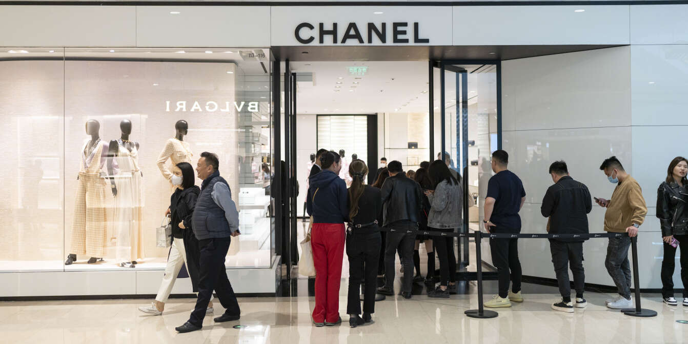 Hong Kong, China. 12th Feb, 2022. Shoppers walk past a commercial  advertisement of the French luxury