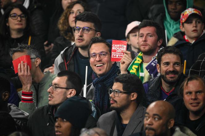 Un spectateur brandit un tract « carton rouge » contre la réforme des retraites, samedi 29 avril 2023, au Stade de France, à Saint-Denis (Seine-Saint-Denis).