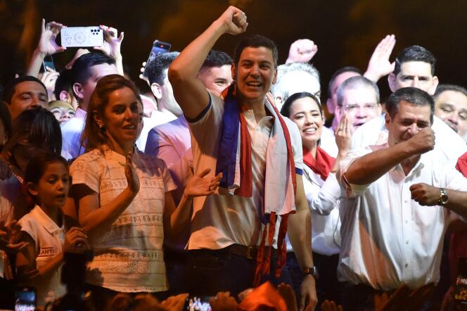 Paraguayan presidential candidate for the Colorado Party, Santiago Peña (C), celebrates next to with his wife, Leticia Ocampos de Pea (L), and Paraguayan former President Horacio Cartes, after winning the presidential election in Asuncion on April 30, 2023.