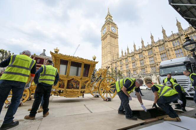 Workers transport the 17th century State Coach to be on display at the Palace of Westminster to commemorate the coronation of Britain's King Charles, in London.