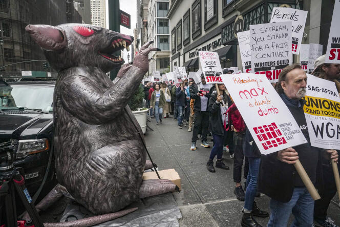 An organized labor symbol of a giant inflatable rat, left, is displayed as members of The Writers Guild of America picket outside Peacock NewFronts, in New York, on Tuesday, May 2, 2023.