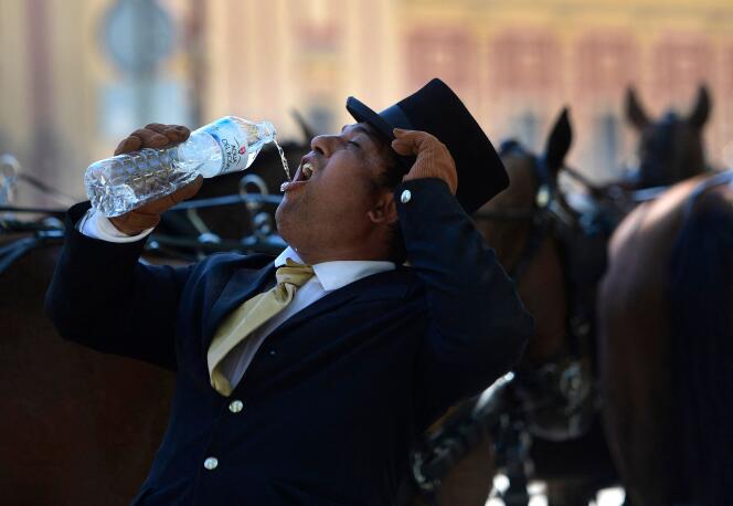 Un cochero bebe agua durante la ola de calor temprana en Sevilla el 26 de abril de 2023.