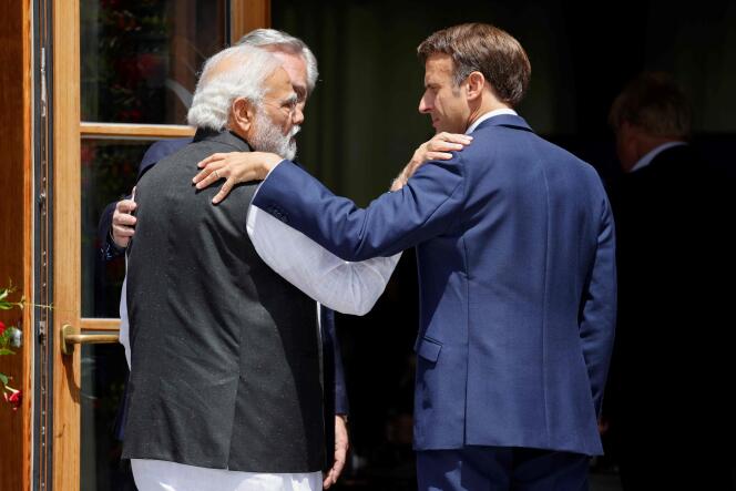India's Prime Minister Narendra Modi (L) and France's President Emmanuel Macron embrace as they arrive at Elmau Castle, southern Germany, June 27, 2022.
