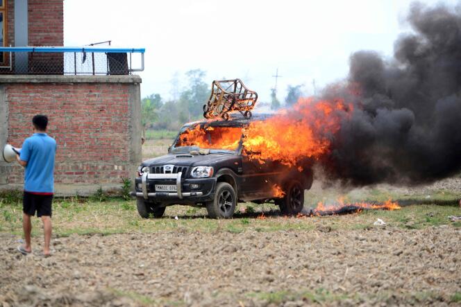 De la fumée s’échappe d’un véhicule prétendument brûlé par la communauté meitei, qui proteste pour demander son inclusion dans la catégorie des tribus répertoriées, à Imphal, la capitale de l’Etat indien de Manipur.