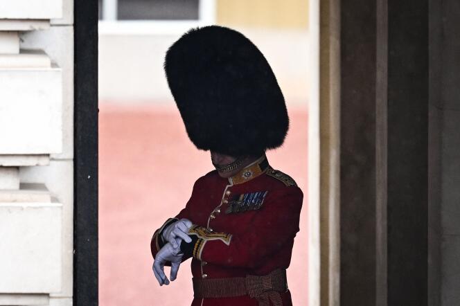 Un garde regarde sa montre avant le début de la procession du roi.