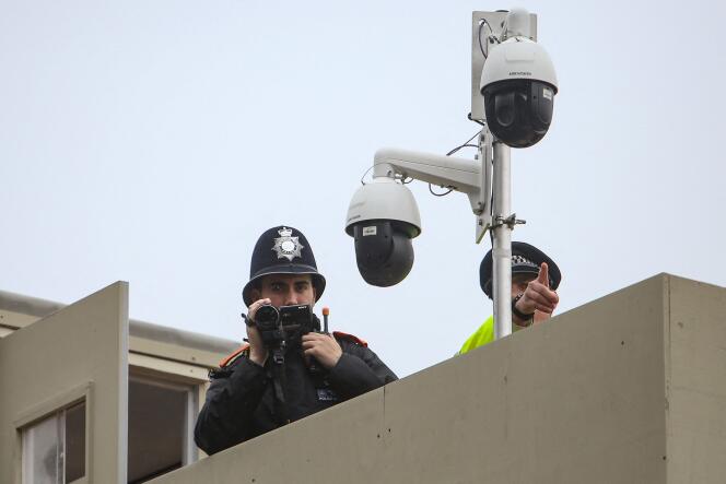 Des policiers filment des membres du groupe antimonarchiste Republic lors d’une manifestation à Trafalgar Square, à Londres, le 6 mai 2023. 