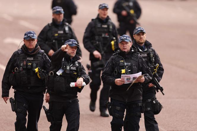 Des policiers armés se tiennent sur le parcours de la procession. Pour l’événement, la police avait mobilisé plus de 11 000 agents, pour ce qui est, à ce jour, une de ses plus importantes opérations de sécurité.