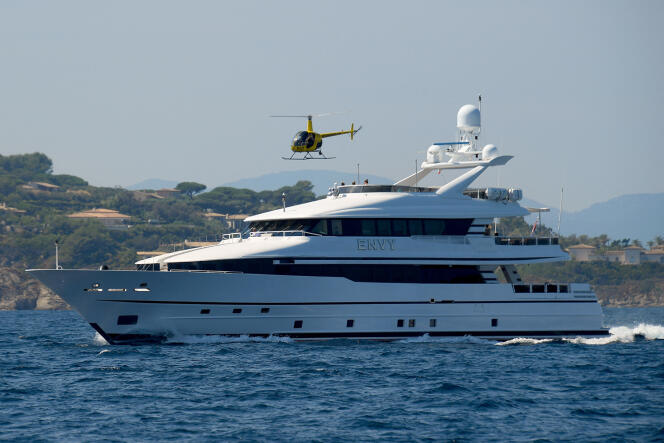 A helicopter flies over a yacht sailing on the Mediterranean Sea, off the coast of the Gulf of Saint-Tropez in southern France, on September 7, 2021. 