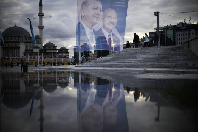 Des piétons passent devant une bannière gigantesque du président turc et candidat à la présidence de l’Alliance du peuple, Recep Tayyip Erdogan, place Taksim, à Istanbul, le 10 mai 2023. 