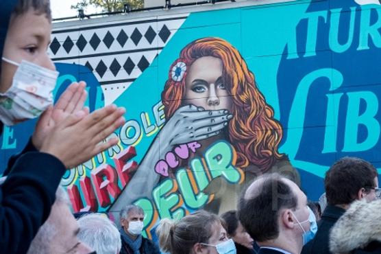 Ceremonia en memoria de Samuel Paty, frente a un fresco del artista Alexandre Sarrat, en Eragny-sur-Oise (Val-d'Oise), 16 de octubre de 2021.