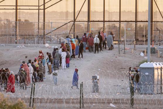 Inmigrantes esperan ser recogidos por agentes estadounidenses en El Paso, Texas, en la frontera entre Estados Unidos y México, el 12 de mayo de 2023.