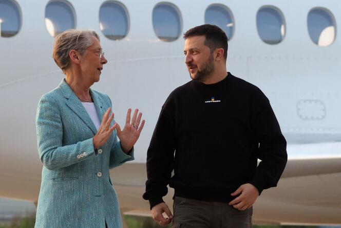 Ukraine's President Volodymyr Zelensky (R) is welcomed by French Prime minister Elisabeth Borne upon his arrival at Villacoublay Air Base, southwest of Paris, on May 14, 2023. Ukraine's President Volodymyr Zelensky arrived in Paris for talks with French President Emmanuel Macron, after Germany pledged unwavering support for Kyiv ahead of a widely expected counter-offensive. (Photo by Thomas SAMSON / POOL / AFP)