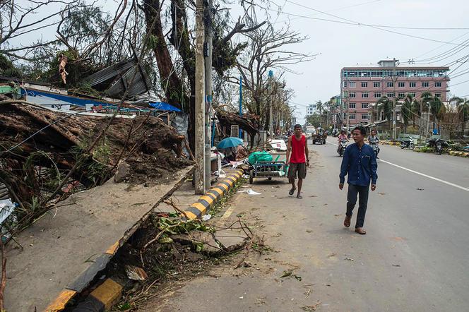 Des habitants passent devant des bâtiments endommagés par le cyclone Mocha à Sittwe, dans l’Etat de Rakhine, en Birmanie, lundi 15 mai 2023.