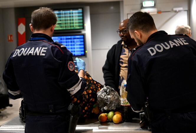 Customs officers check the luggage of pengers arriving at Paris-Charles de Gaulle airport, in Roissy (Val-d'OIse), on February 15, 2023.