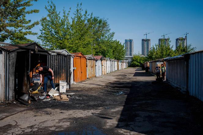 A man cleans his garage after it was hit by a Russian missile strike. Kyiv, May 18, 2023.