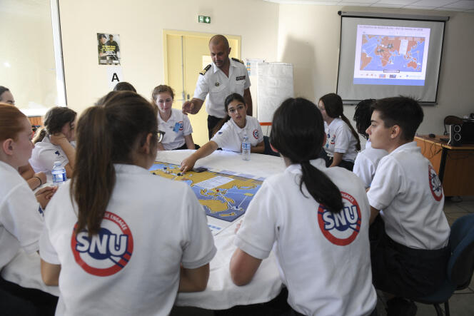 A French soldier explains to young people how to play a strategic war game on the air base 116 of Luxeuil-Saint-Sauveur (Haute-Saône), during the universal national service, June 24, 2019.