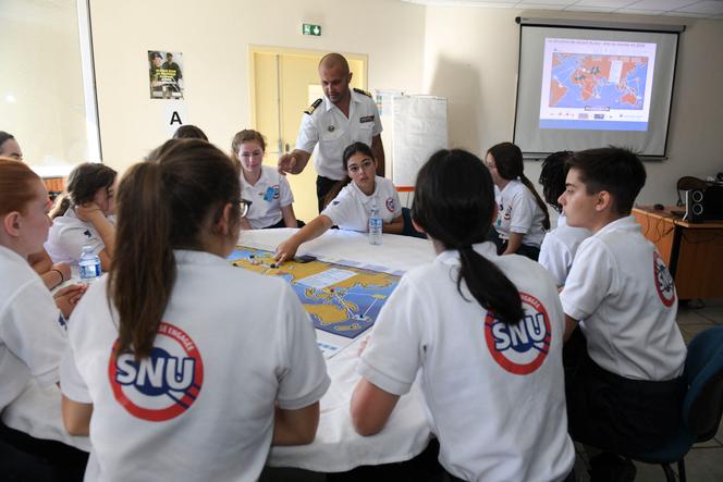 Un militaire français explique à des jeunes comment jouer à un jeu de guerre stratégique sur la base aérienne 116 de Luxeuil-Saint-Sauveur (Haute-Saône), lors du service national universel, le 24 juin 2019.