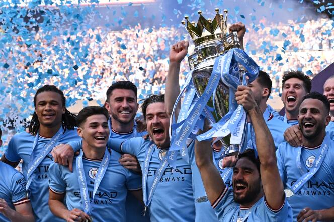 Midfielder Ilkay Gundogan lifts the Premier League trophy as Manchester City players celebrate their title after the game against Chelsea at the Etihad Stadium in Manchester on May 21, 2023.