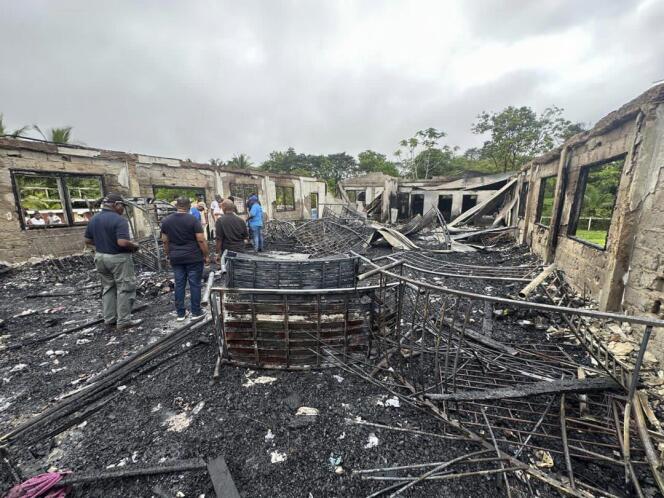 In this photo provided by Guyana's Department of Public Information, the dormitory of a secondary school is burned in Mahdia, Guyana, Monday, May 22, 2023. 
