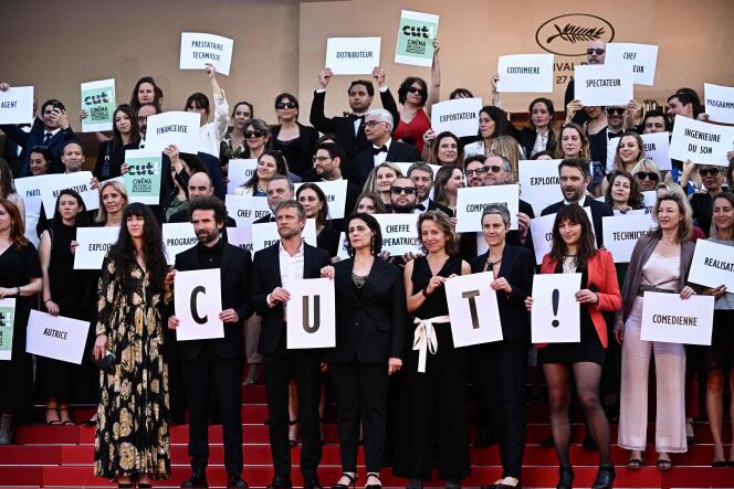 Members of 'CUT!'  (Cinema Uni pour la Transition) hold placard as they arrive for the screening of the film 