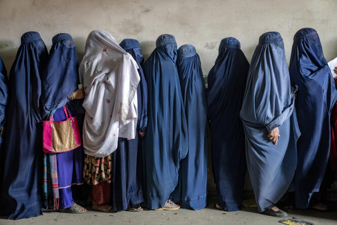 Afghan women wait to receive food rations distributed by a humanitarian aid group, in Kabul, Afghanistan, Tuesday, May 23, 2023. 