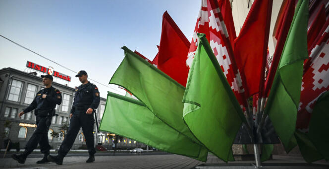 Des policiers passent devant un bouquet de drapeaux biélorusses à Minsk, le 20 juillet 2022.