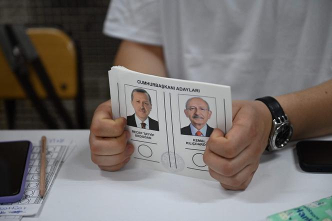 Une personne tient des bulletins de vote pour les candidats du second tour de la présidentielle turque, Recep Tayyip Erdogan et Kemal Kiliçdaroglu, dans un bureau de vote, à Istanbul, le 28 mai 2023.
