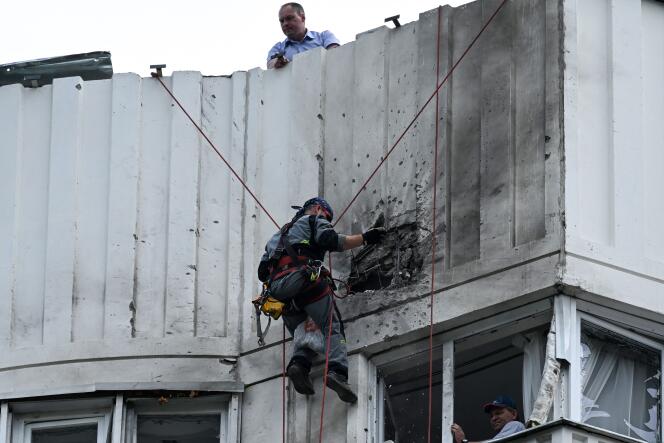 Un spécialiste inspecte la façade endommagée d’un immeuble d’habitation après une attaque de drone à Moscou, le 30 mai 2023.