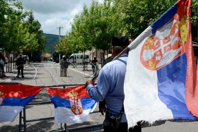 A man carries a Serbian flag in front of KFOR soldiers in Zvecan, northern Kosovo, May 31, 2023.