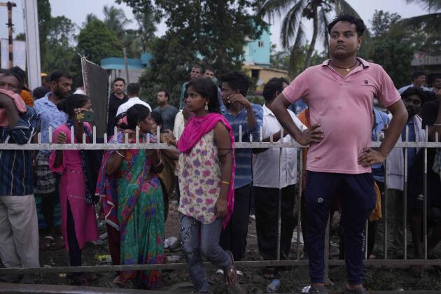 Des personnes observent les opérations de sauvetage sur le site de l’accident de trains dans le district de Balasore, en Inde, le 3 juin 2023.