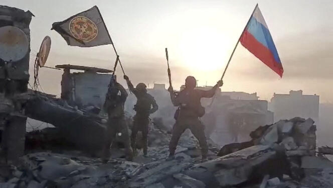 Mercenarios ondean banderas de Rusia y del Grupo Wagner en un lugar no identificado.  Esta imagen se obtuvo de un video publicado el 20 de mayo de 2023 con una declaración de Yevgeny Prigozhin sobre la toma total de la ciudad ucraniana de Bakhmout. 
