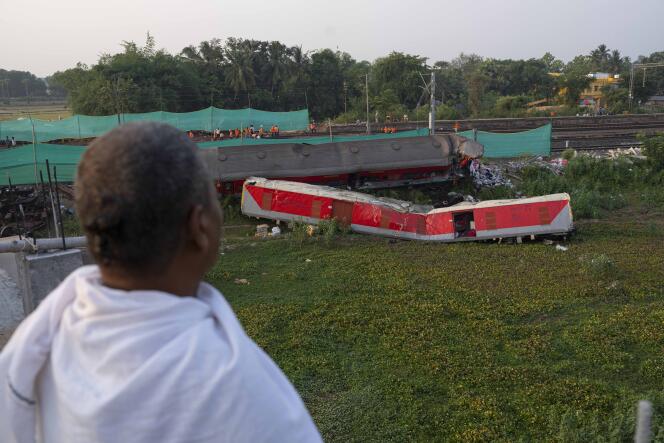 A Hindu priest looks at the wreckage of two passenger trains which derailed on Friday in Balasore district, India's Orisha state, Monday, June 5, 2023.