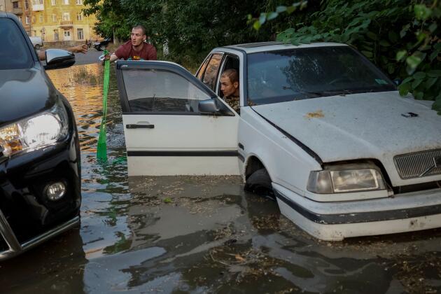 Los residentes de Kherson intentan liberar su automóvil de una calle inundada el 6 de junio de 2023. 